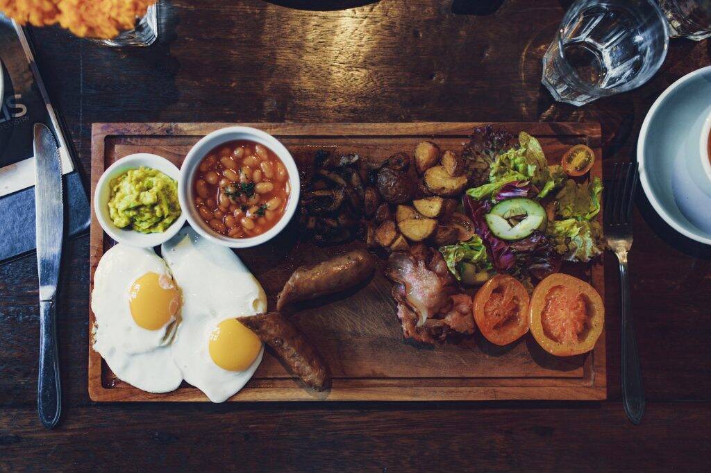 grilled vegetables and fried egg with beans and sausage